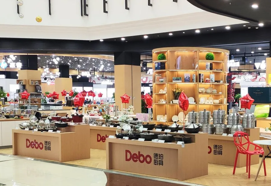 A Debo department-store counter with cookware on wooden tables and the red logo